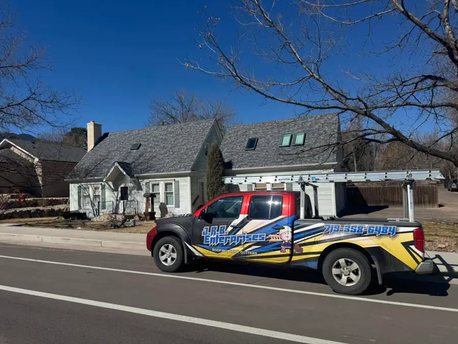 New Owens Corning Duration roof in Slatestone Gray, exterior paint in Sherwin-Williams SuperPaint, and new gutters on a Colorado Springs home, with the J.R.B. truck out front